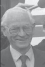 Black and white head and shoulders photograph of Stephen McGonagle, a former Member of Seanad Éireann, standing in a garden.