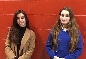 Photo of teacher and student in front of a red wall