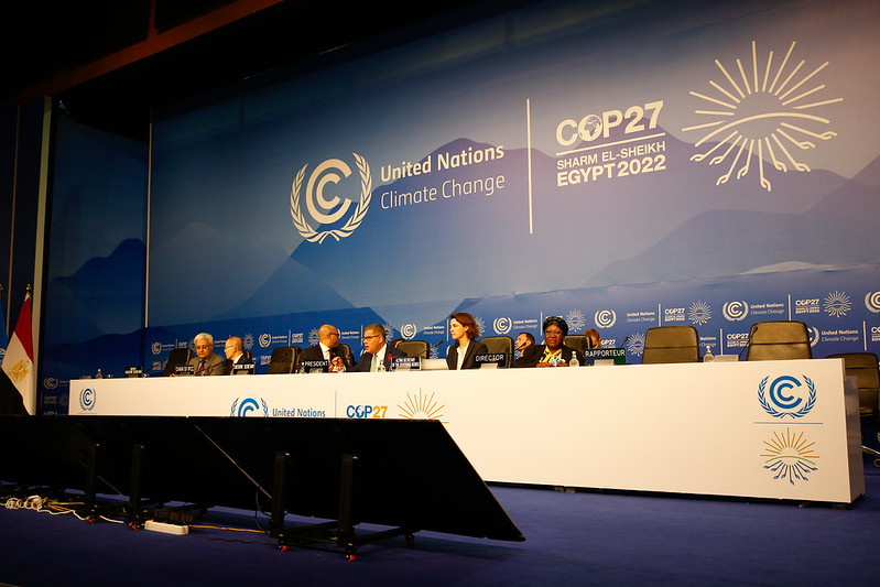 People seated at a long table at the COP27 climate conference