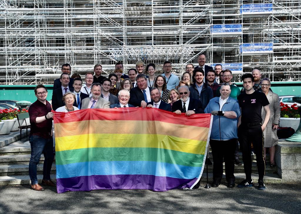 Staff and Members of the Oireachtas holding the Rainbow Flag outside Leinster House