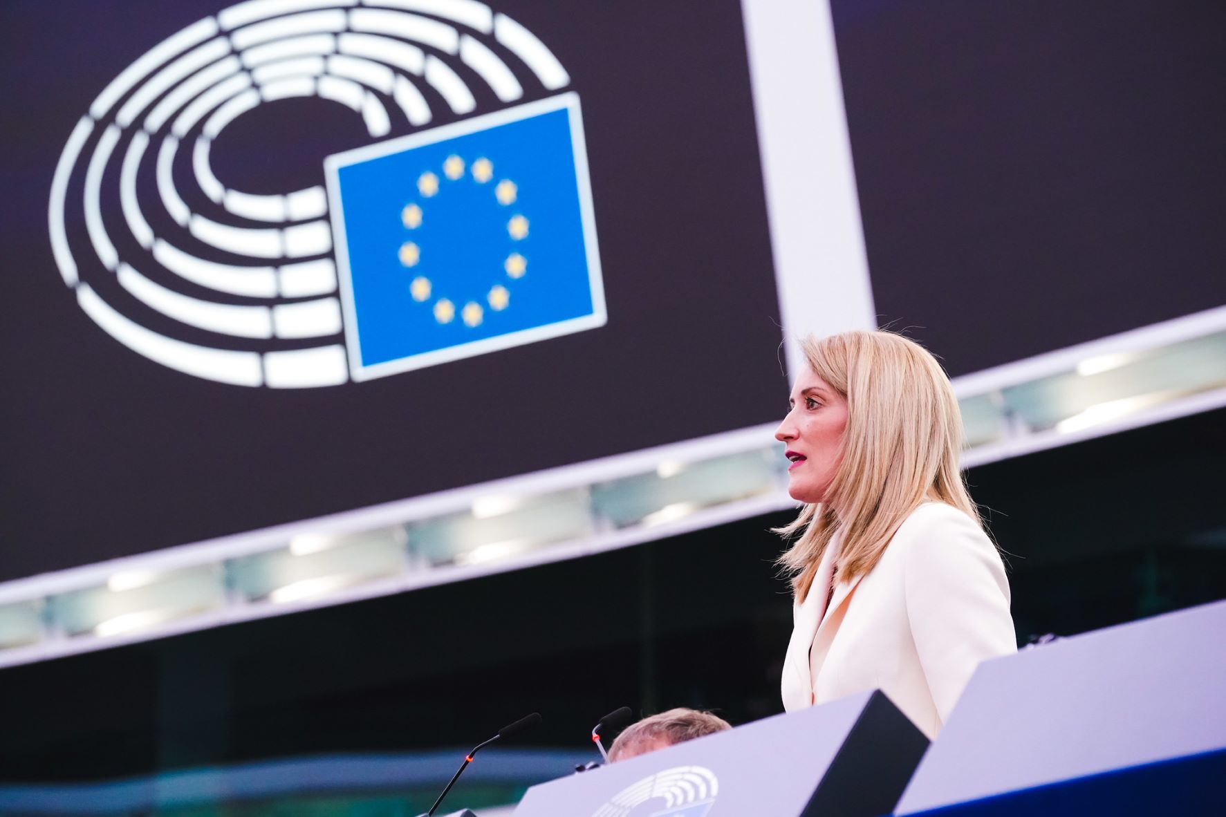Colour photograph of European Parliament President Roberta Metsola standing at a lectern addressing the European Parliament on her election