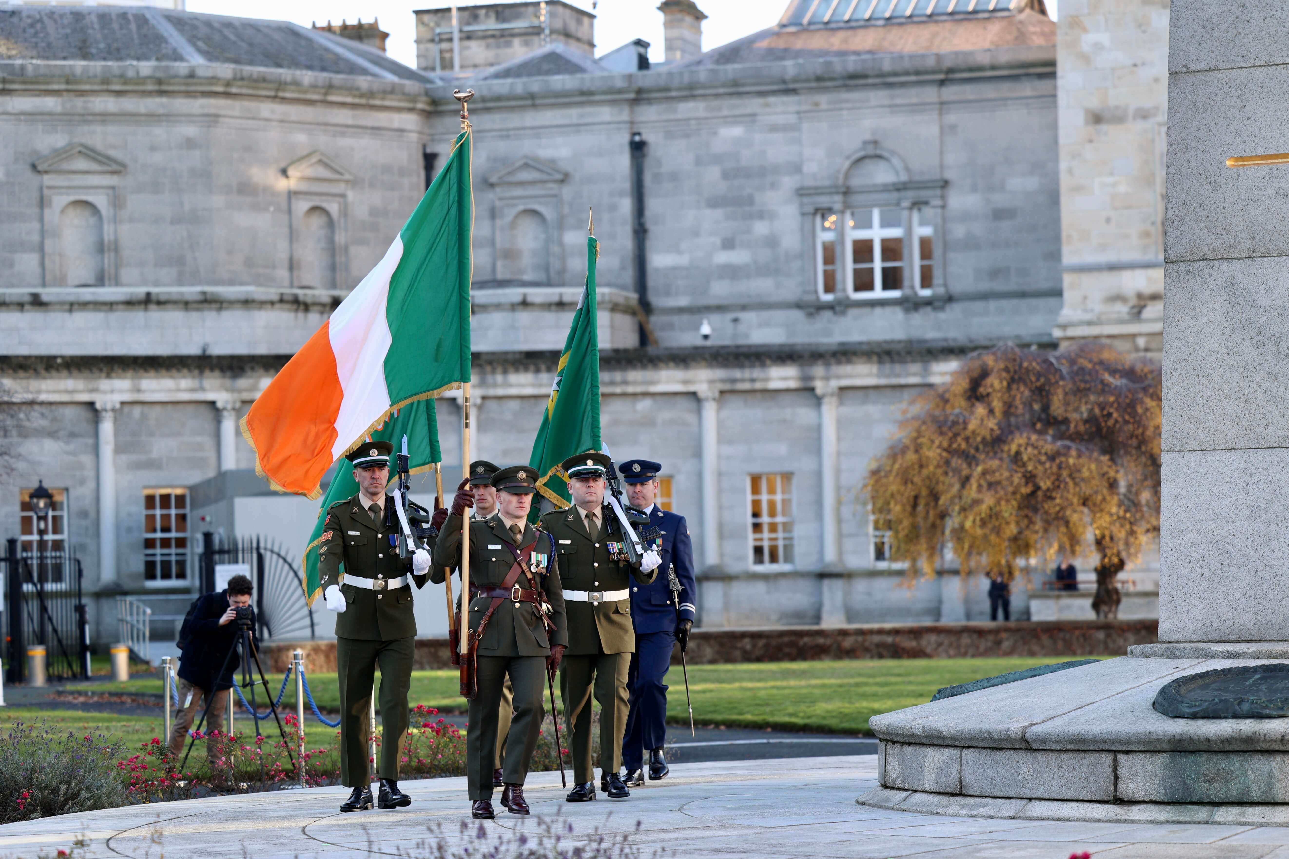 The Irish tricolour being escorted by military personnel on Leinster Lawn at Leinster House during a commemorative event